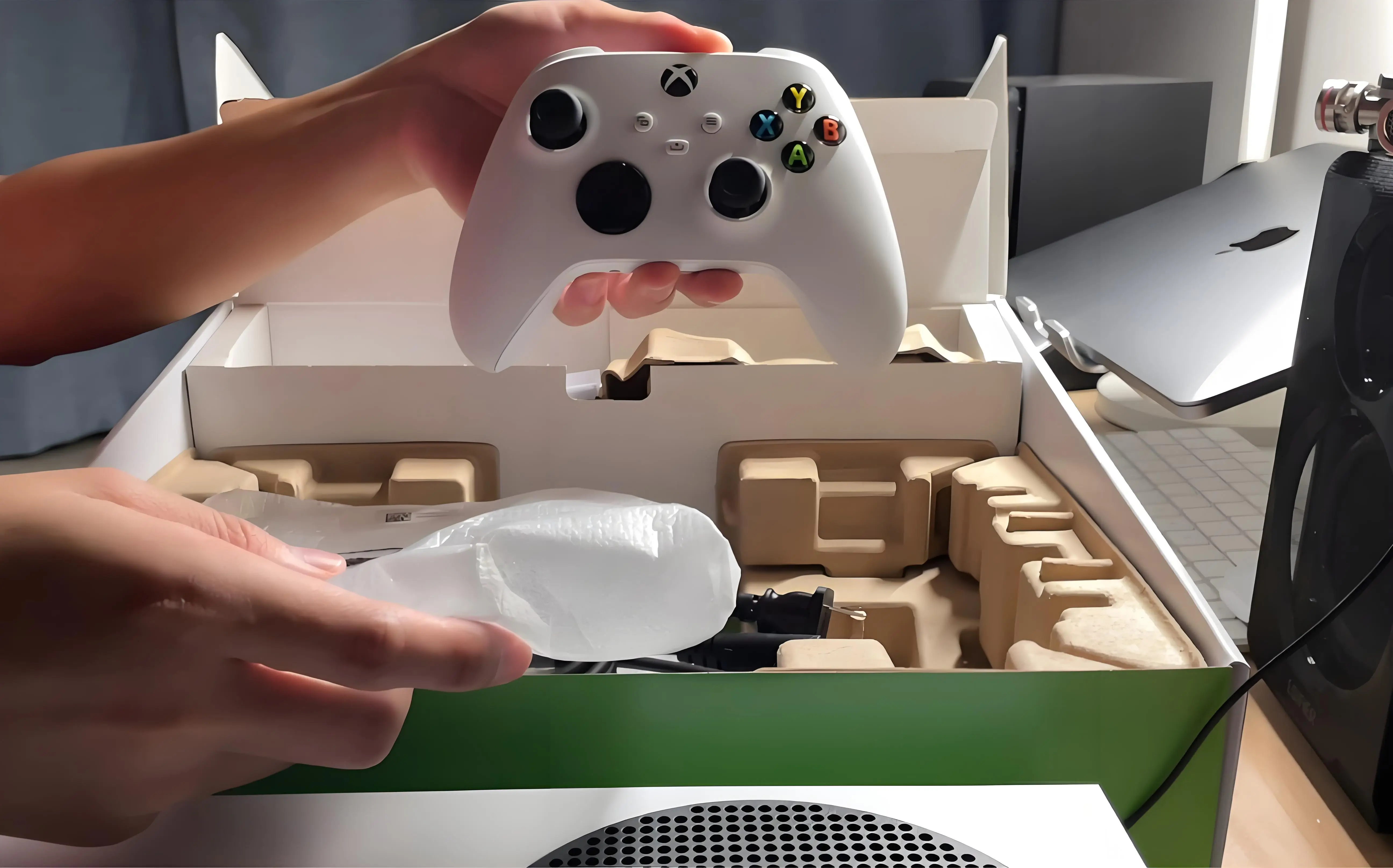 A person carefully cleaning their Xbox Series S and packing it into its original box.